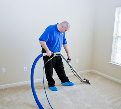 male cleaner performing Office Cleaning using vacuum clean